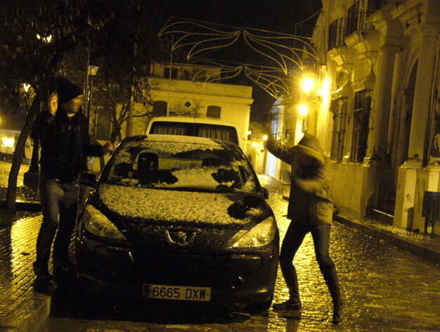 Dos j&oacute;venes juegan con la nieve ca&iacute;da sobre un coche en el municipio serrano de Cazalla de la Sierra.

Foto: B.Vargas/Juan Carlos V&aacute;zquez