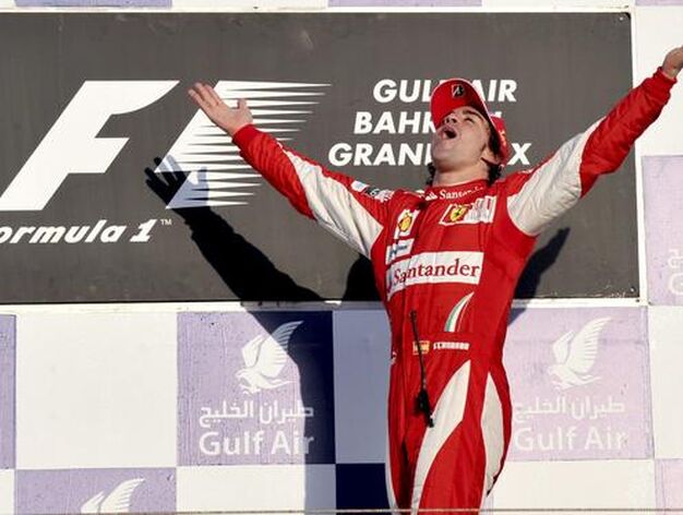 Alonso sube al podio extasiado por su primera victoria de rojo. / EFE