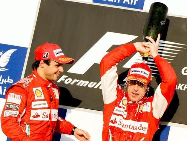 Alonso se echa el champagne por la cabeza en el podio. / EFE