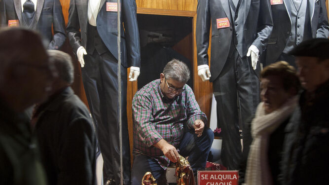 Un comerciante de la calle Rosario coloca las imágenes de un nacimiento en el escaparate.