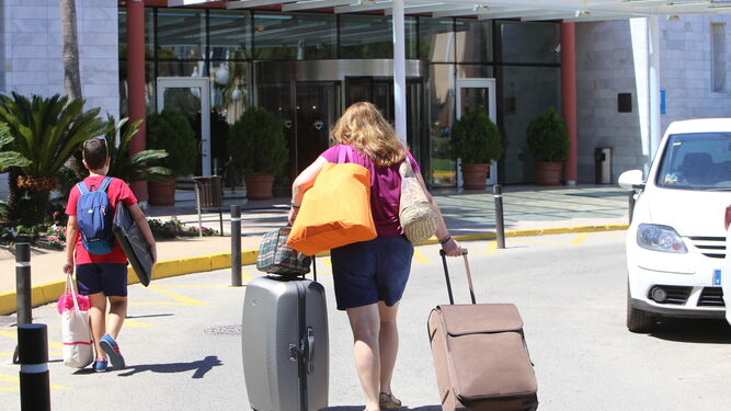 Clientes con maletas a la entrada de un hotel.