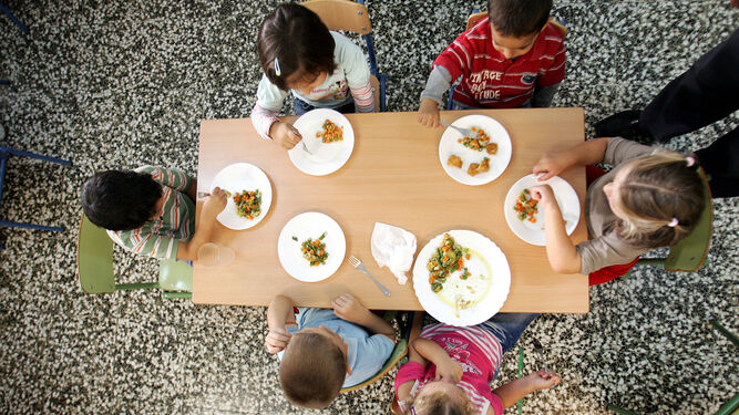 Unos pequeños almorzando en un comedor escolar.