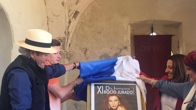 La alcaldesa y el hermano de la cantante chipionera, descubriendo el cartel anunciador de la jornada en el Castillo.