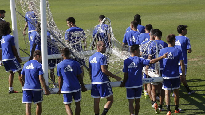 Los jugadores del Cádiz trasladan una portería durante un entrenamiento en la Ciudad Deportiva de El Rosal.