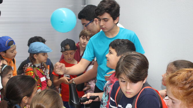 Alumnos de Secundaria explican a los de Primaria uno de los experimentos presentados ayer en la II Feria de la Ciencia.