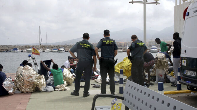 Efectivos de la Guardia Civil junto a los inmigrantes de origen subsahariano rescatados de la patera con la que intentaban llegar a Melilla.