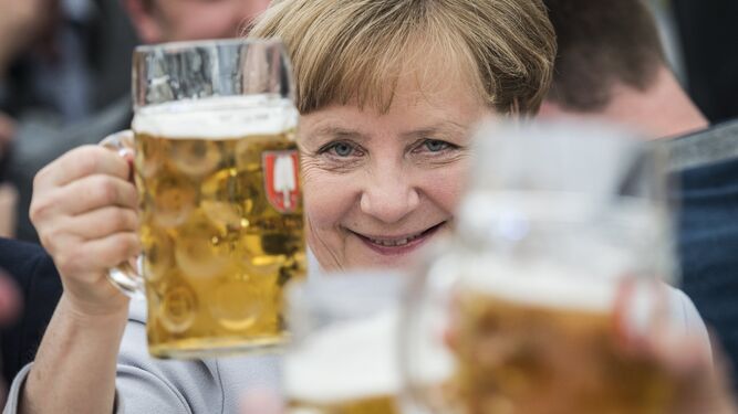 Angela Merkel brinda con una jarra de cerveza.
