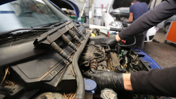 Un mecánico de un taller autorizado, durante la reparación de un vehículo.