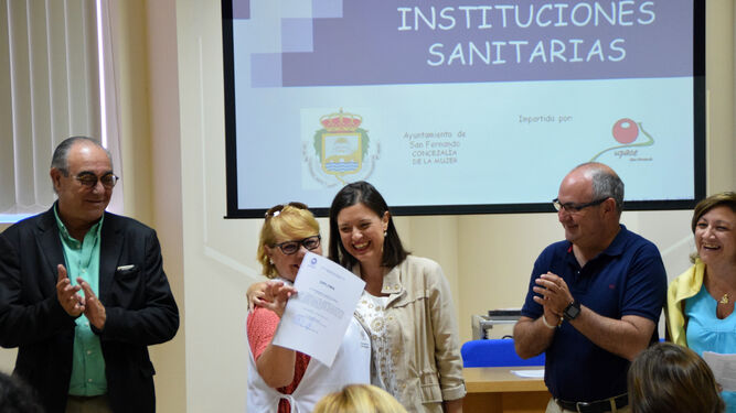 Una de las participantes del curso recoge su diploma de manos de Cavada.
