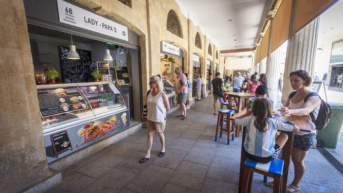 Varias personas compran diferentes productos en el Rincón Gastronómico del Mercado Central.