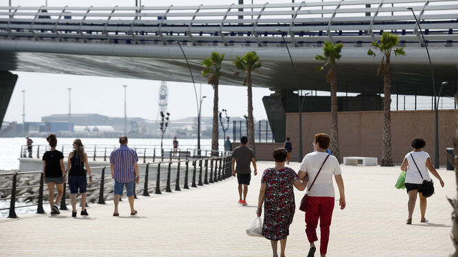 Varias personas pasean por el nuevo paseo marítimo que pasa por debajo del segundo puente.