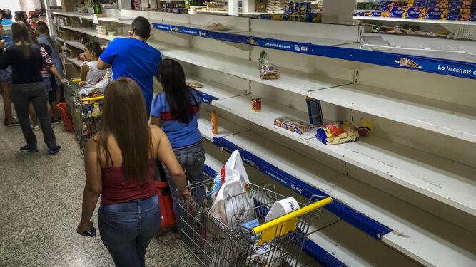 Un grupo de personas hace acopio de víveres y productos de primera necesidad en un supermercado de Caracas.