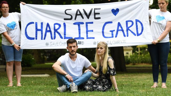 Los padres de Charlie Gard, con una pancarta pidiendo que salven a su hijo