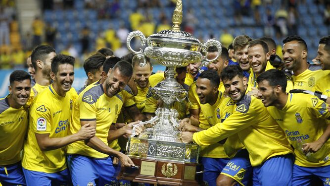 Los jugadores de Las Palmas comparten el peso de la copa de ganador del Trofeo Carranza.