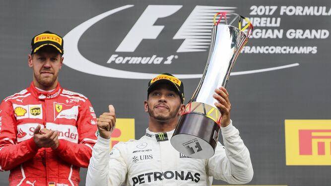 Hamilton alza el trofeo ante Vettel.