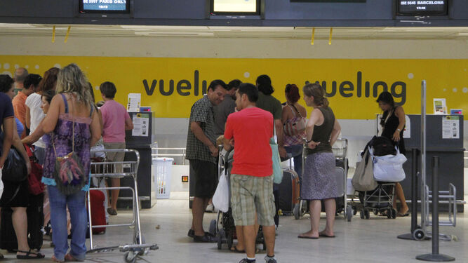 Pasajeros hacen cola en el aeropuerto de Sevilla
