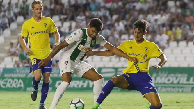 Marcos Mauro se lanza al césped para quitarle el esférico al ex cadista del Córdoba Jona, en el partido de la primera jornada de Liga.