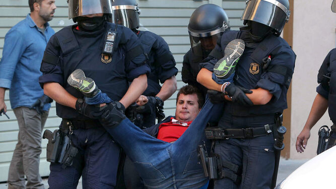 Varios mossos desalojan a un joven.