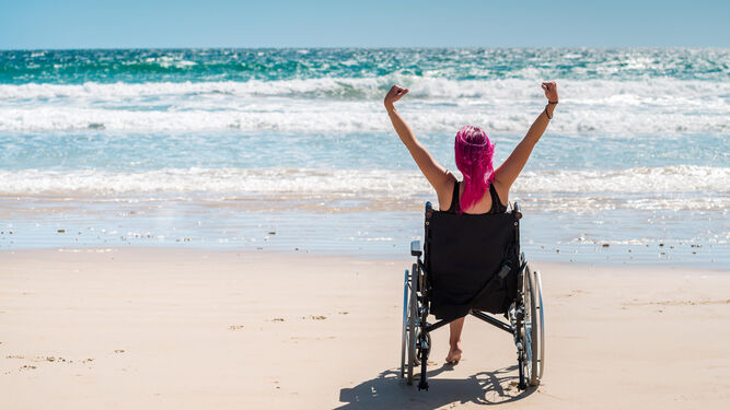 Una joven en silla de ruedas disfruta de la playa.
