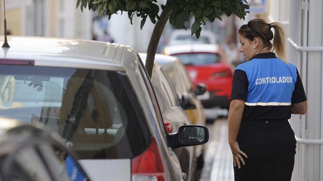 Una trabajadora de la empresa de la zona azul de San Fernando, comprueba los tickets de hora de los vehículos, ayer en el centro.