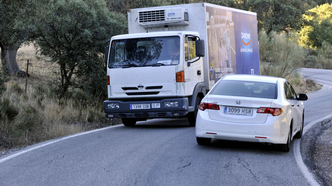 Una estampa común en la carretera de Lora, donde los vehículos casi se rozan, como en la imagen de ayer, para salvar las curvas.