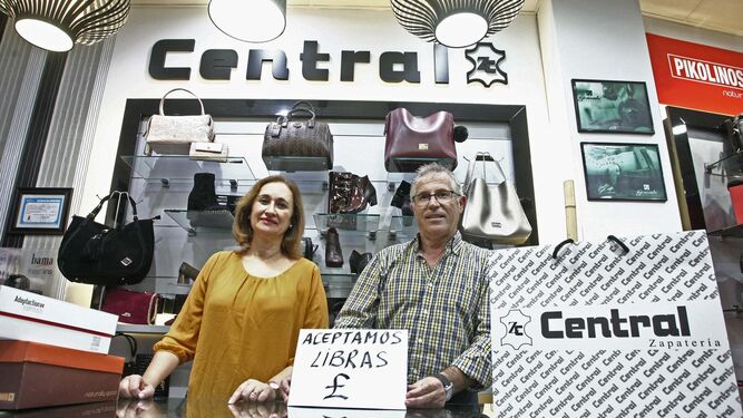 María Machado y Antonio Pérez, de la Zapatería Central, muestran un cartel en el que anuncian que la libra es bienvenida.