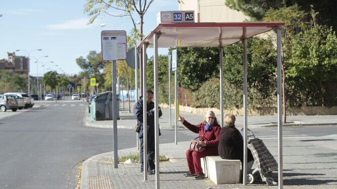 Tres personas esperan el autobús en una de las paradas suprimidas,  en la calle Padre José Sebastián Bandarán.