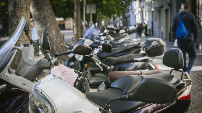 Multas asomando por los manillares y sillines de las motos que amanecieron ayer aparcadas en la plaza de Mina.
