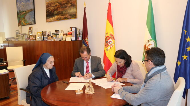 El alcalde durante la firma del convenio con representantes de la entidad.