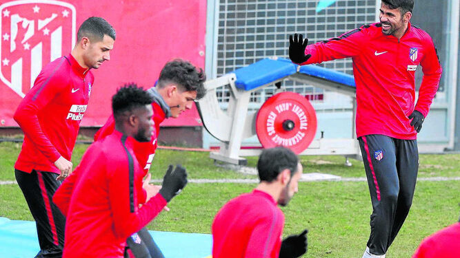 Diego Costa bromea mientras sus compañeros, con Vitolo entre ellos, se ejercitan.