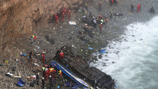 Bomberos y policías participan en las labores de rescate de un autobús siniestrado a 45 kilómetros de Lima (Perú).