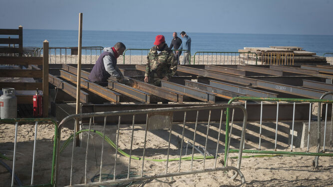 Trabajadores, durante el montaje de la estructura de la plataforma del nuevo chiringuito, en una imagen tomada ayer por la mañana.