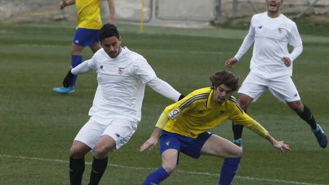 Duarte se gira protegiendo el esférico de la presencia amenazante de dos jugadores del Sevilla C.