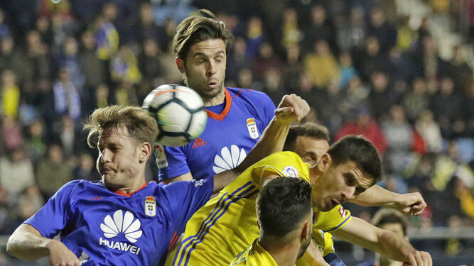 Kecojevic salta con dos jugadores del Oviedo en busca del esférico en presencia de Jona.