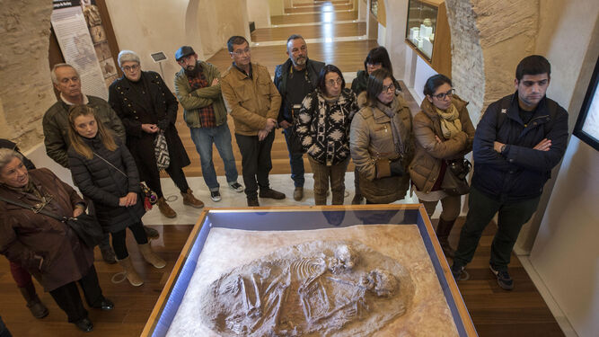Un grupo de personas atiende a las explicaciones de la guía sobre la figura de 'Los Enamorados' en el Castillo de San Romualdo.