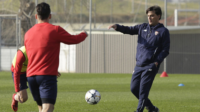 Vincenzo Montella le lanza el balón a un jugador del Sevilla con Roque Mesa, de espaldas, reclamándoselo.