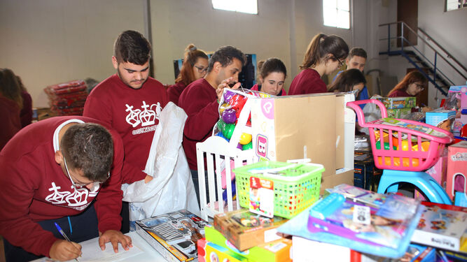 Los jóvenes voluntarios preparan los paquetes con los regalos para los niños, durante la pasada campaña de Reyes.