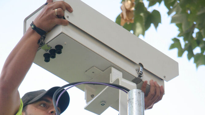 Un operario instala una cámara de vigilancia del tráfico.