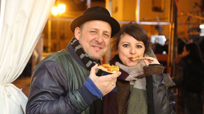 Dos visitantes del festival degustando una pizza.