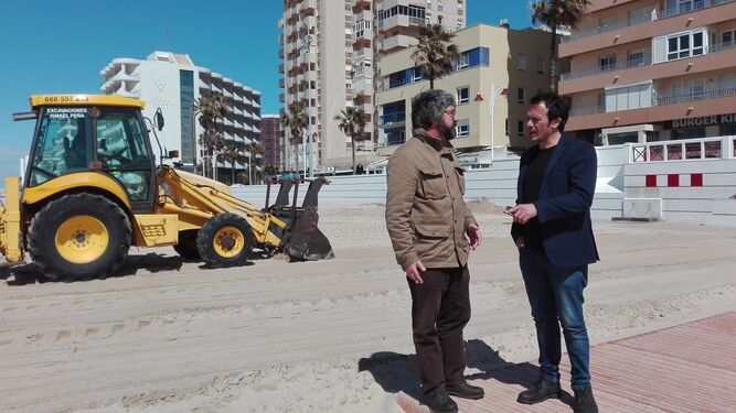 El alcalde charla con uno de los técnicos a pie de playa.