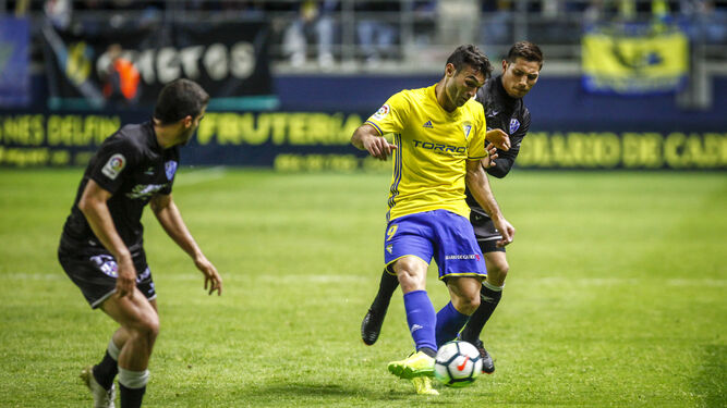 Barral controla el balón marcado por un rival del Huesca.