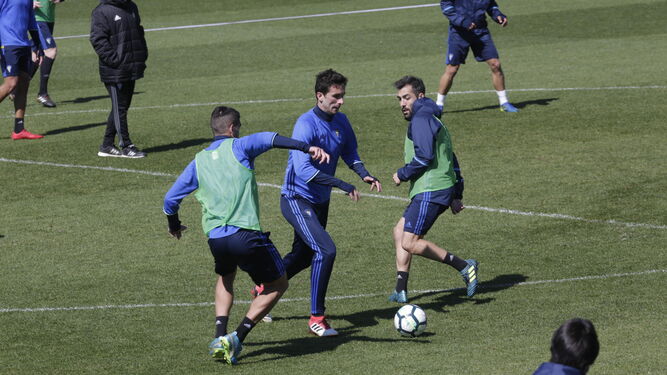 Kecojevic, que vuelve tras sanción, se marcha con el balón entre Garrido y Perea en un partidillo de entreno.