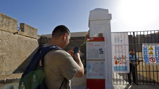 Un turista ante la puerta del Castillo de Santa Catalina.
