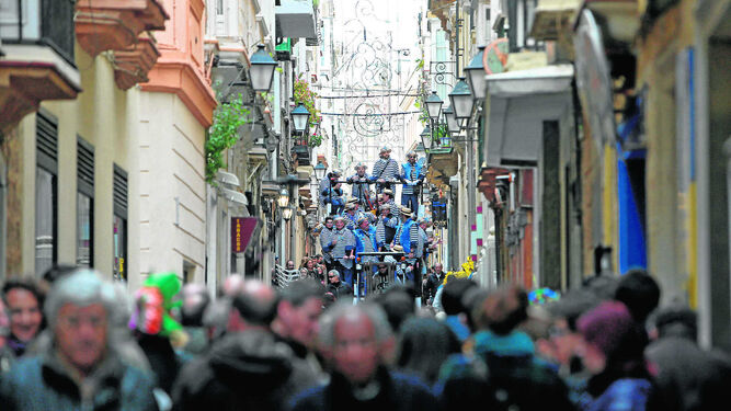 Una calle repleta de público para escuchar un coro en Carnaval.