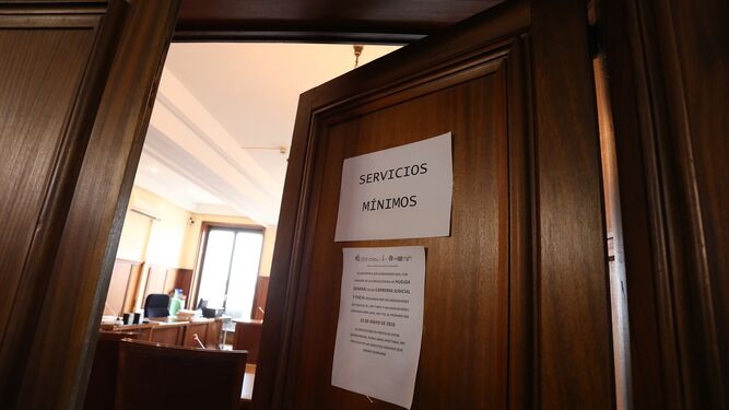 Un cartel informa de los servicios mínimos en la puerta de una de las salas de la Audiencia.