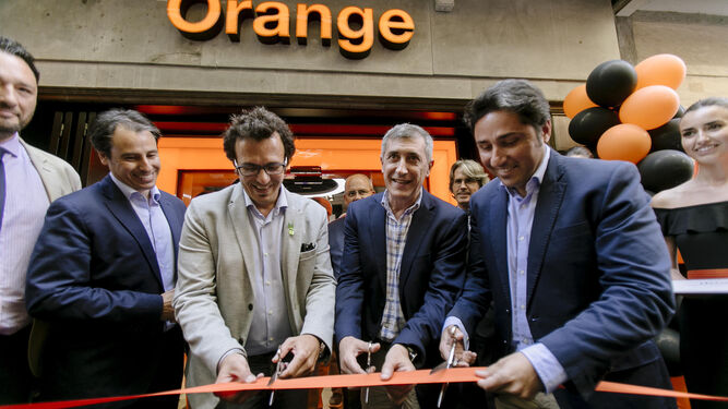 El alcalde, junto a directivos de Orange y los propietarios de la tienda, cortan la cinta de inauguración.
