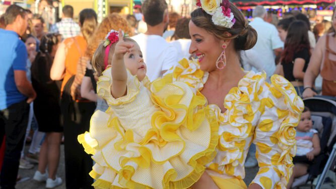 Una pequeña, vestida de flamenca, vive junto a su madre su primera feria