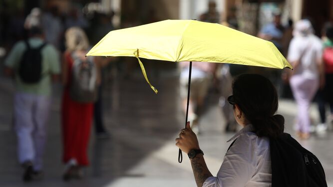 Una turista protegiéndose del calor en Málaga.