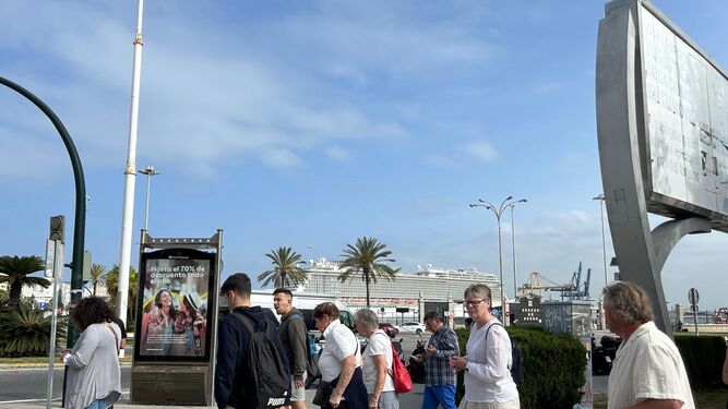 Varios turistas a punto de cruzar la Cuesta de Las  Calesas con el Norwegian Escape de fonto atracado en el Muelle Alfonso XIII del puerto de Cádiz