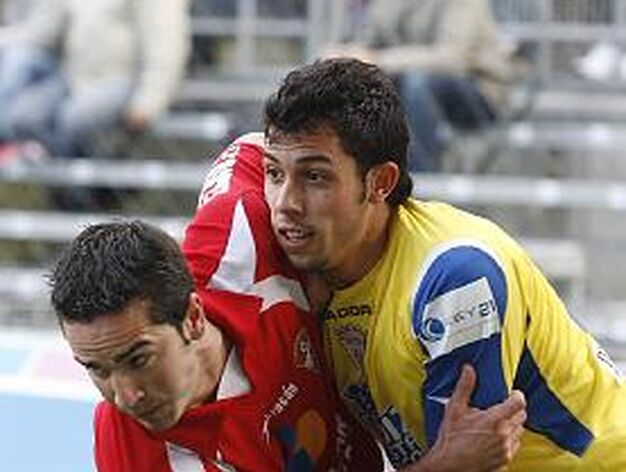 Carlos se agarra a un rival en la disputa por un bal&oacute;n. 

Foto: Joaqu&iacute;n Pino